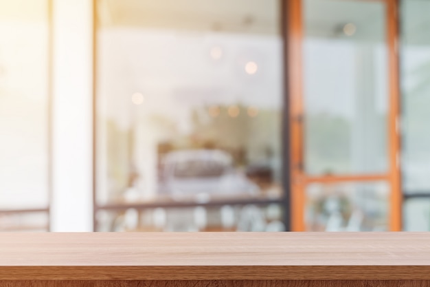 Empty wooden table and blurred people in coffee shop background