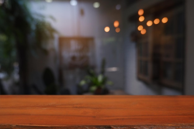 Empty wooden table in front of abstract blurred Cafe restaurant house interior For montage produc