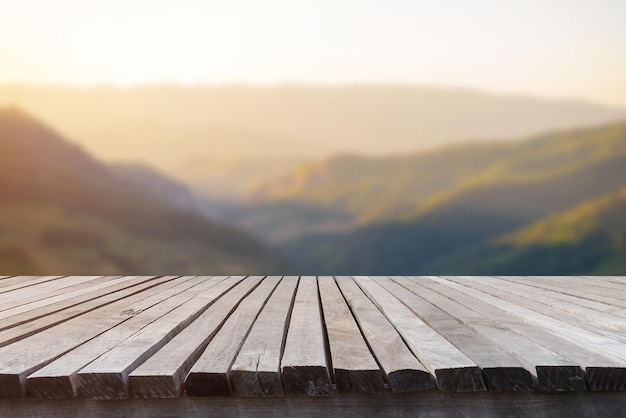 Empty wooden table in front of blurred beautiful grassland view and mountain with beautiful sunrise background of nature Can be used for display or montage for show your products