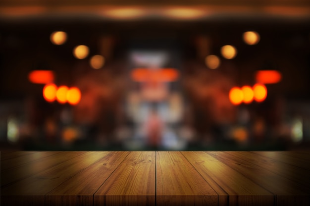 Empty wooden table top with blurred coffee shop.