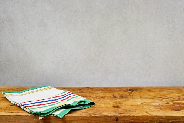 Empty wooden table with tablecloth over gray background