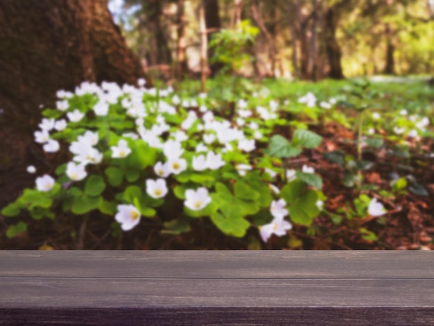 Empty wooden table with wild plant flowers bokeh view for catering or food showcase mockup template