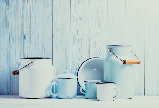 Photo enamelware on the kitchen table over blue wooden wall