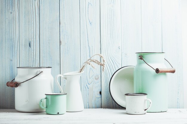 Photo enamelware on the kitchen table over blue wooden wall