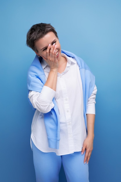 Energetic charismatic shorthaired lady in a casual shirt makes a grimace