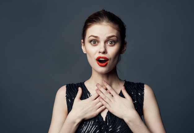 Energetic woman in black dress gestures with hands emotions model surprise delight