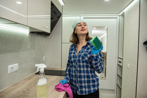 Energetic woman cleans kitchen with modern means of cleaning dirt in inaccessible places