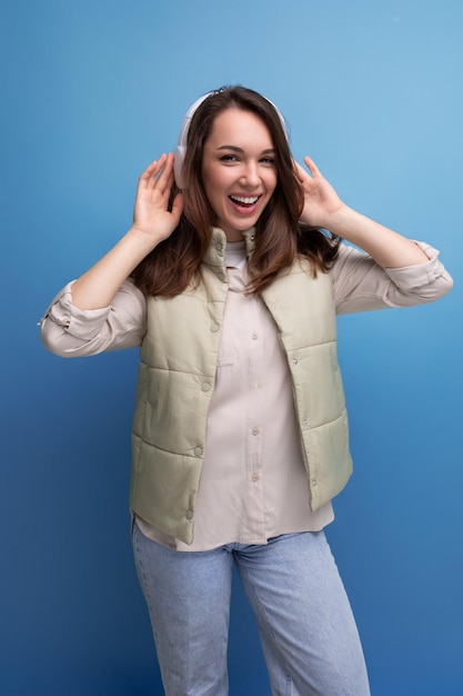 Energetic young brunette woman relaxing to music using headphones and mobile phone