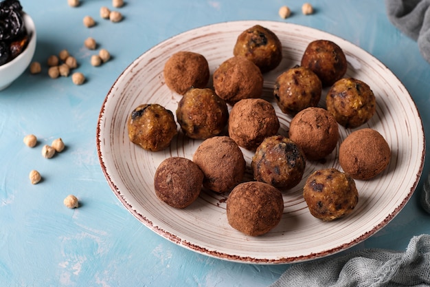 Energy balls of chickpea, prunes, and dates, sprinkled with cocoa on plate