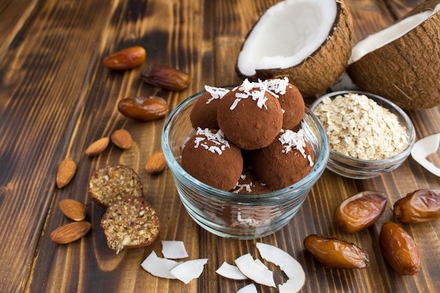 Energy balls with coconut chips, almond, oat cereals and dates in the glass bowl