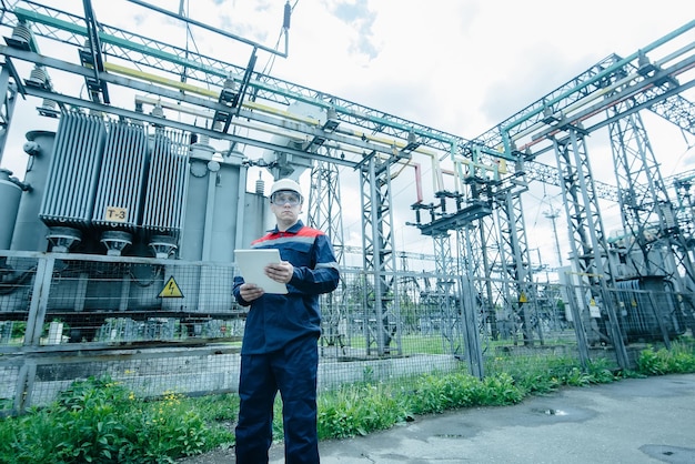 An energy engineer inspects the modern equipment of an electrical substation before commissioning Energy and industry Scheduled repair of electrical equipment