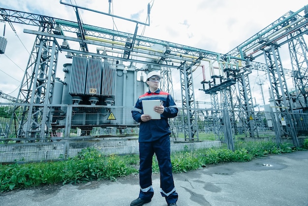 An energy engineer inspects the modern equipment of an electrical substation before commissioning Energy and industry Scheduled repair of electrical equipment