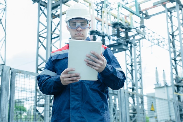 An energy engineer inspects the modern equipment of an electrical substation before commissioning Energy and industry Scheduled repair of electrical equipment