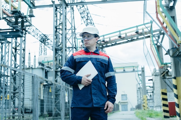 An energy engineer inspects the modern equipment of an electrical substation before commissioning Energy and industry Scheduled repair of electrical equipment