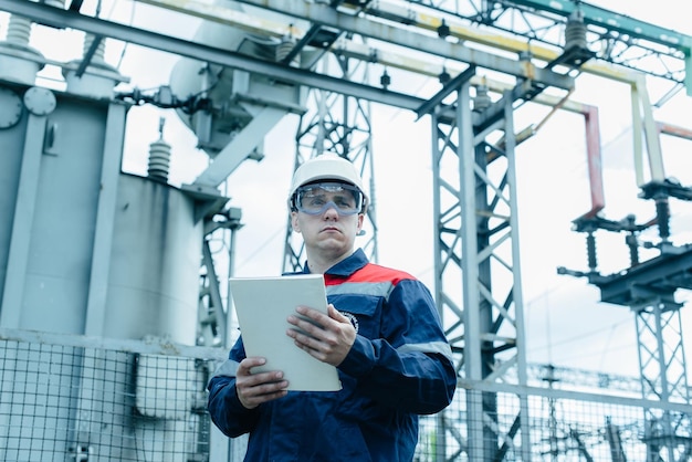 An energy engineer inspects the modern equipment of an electrical substation before commissioning Energy and industry Scheduled repair of electrical equipment