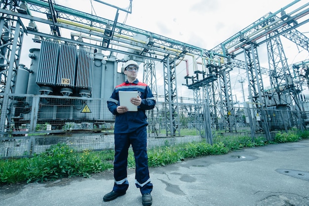 An energy engineer inspects the modern equipment of an electrical substation before commissioning Energy and industry Scheduled repair of electrical equipment