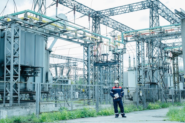 An energy engineer inspects the modern equipment of an electrical substation before commissioning. Energy and industry. Scheduled repair of electrical equipment.