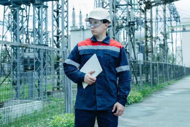 An energy engineer inspects the modern equipment of an electrical substation before commissioning Energy and industry Scheduled repair of electrical equipment