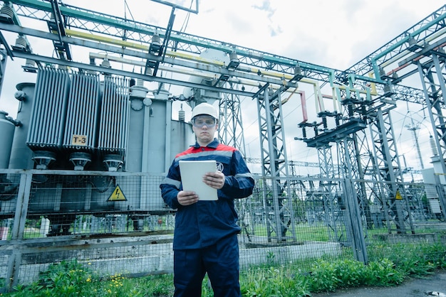 An energy engineer inspects the modern equipment of an electrical substation before commissioning Energy and industry Scheduled repair of electrical equipment