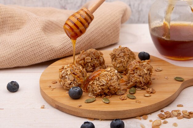 Energy granola bites with honey on a wooden plate