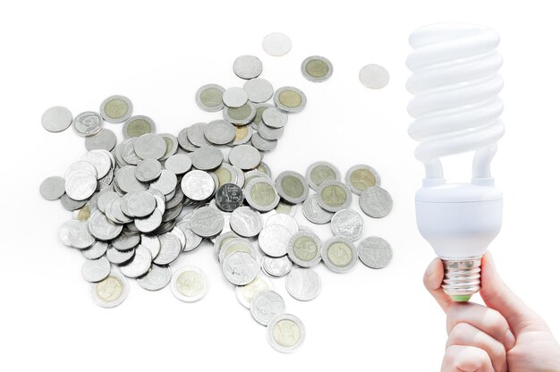 Energy saving concept Woman hand holding light bulb on Coin on white backgroundIdeas light bulb in the hand