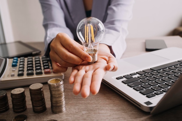 Energy saving light bulb with stacks of coins and shopping cart for saving financial and shopping concept