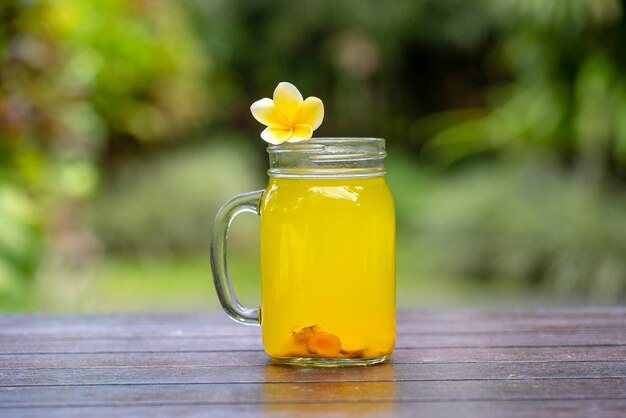 Energy tonic drink with turmeric ginger lemon and honey in glass mug nature background close up