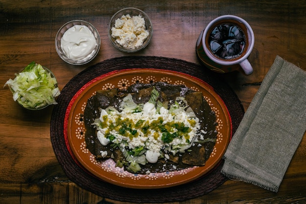 Enfrijoladas served in a clay dish Typical Mexican food Bean tacos with cream and cheese