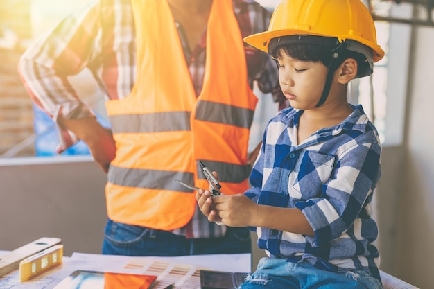 Engineer builder family father day role play teaching son kid at construction site