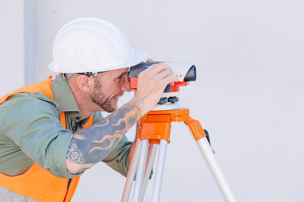 Engineer builder working with Auto Level camera look aim levelling survey construction building floor