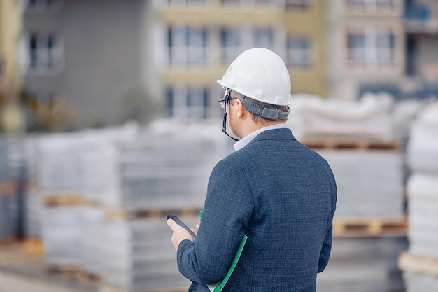 An engineer in the caste supervising the process of building a new house. The architect holding the phone.