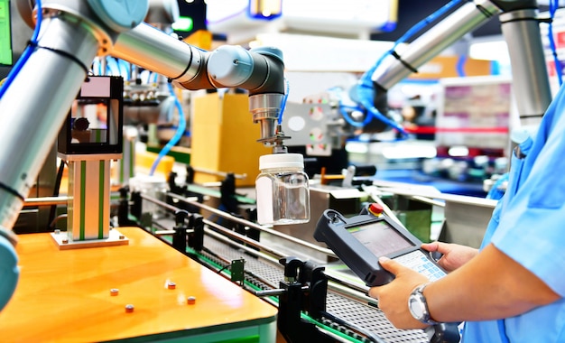 Engineer check and control automation robot arms arranged glass water bottle