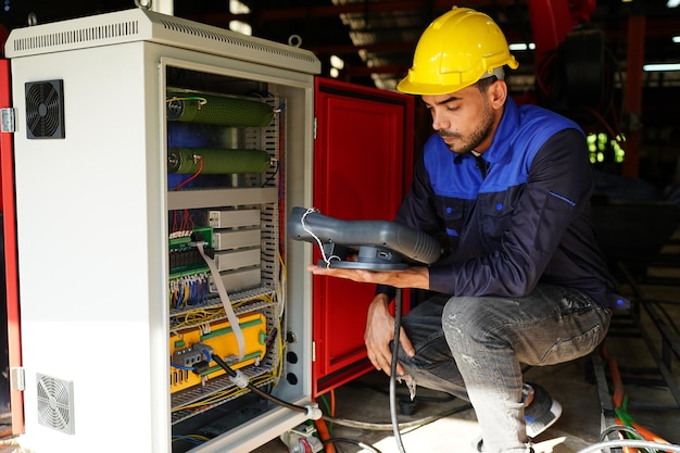 Engineer checking control panel and teaching new Automatics robot arm and operating control machine in factory