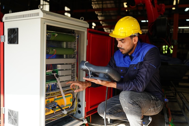 Engineer checking control panel and teaching new Automatics robot arm and operating control machine in factory