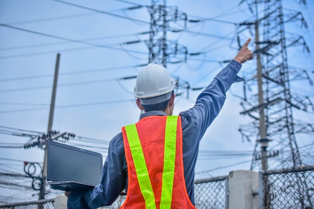 Engineer holding computer notebook high voltage power plant