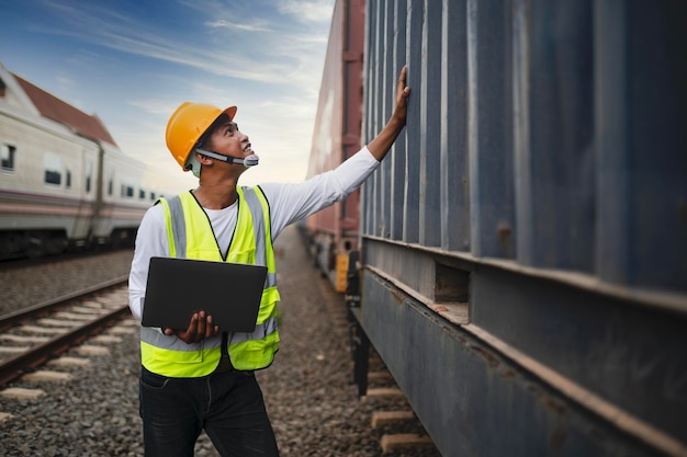 Engineer inspects container train of transport company Distribution and transportation of goods by rail A container train passing through an industrial area