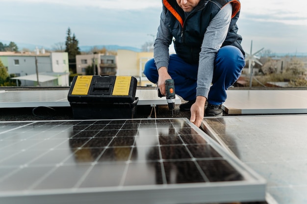 Engineer installing solar photovoltaic panel system using screwdriver Alternative energy concept