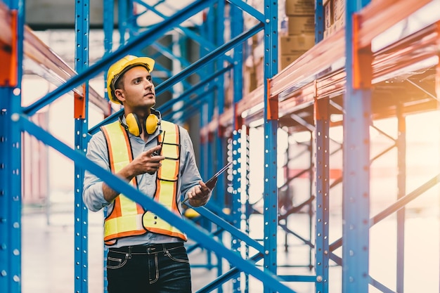 Engineer male checking steel metal construction warehouse shelves structure building