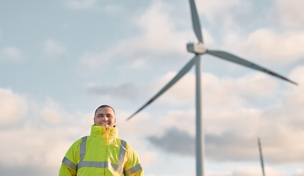 Engineer man stands in a wind turbine field