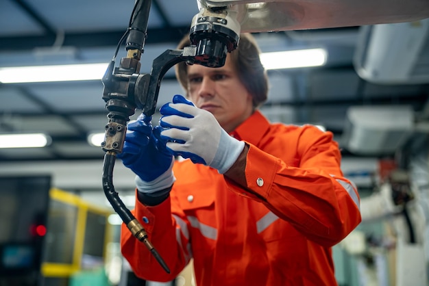 Engineer Man working at industrial robot in factory industrial robotics and digital manufacturing operation