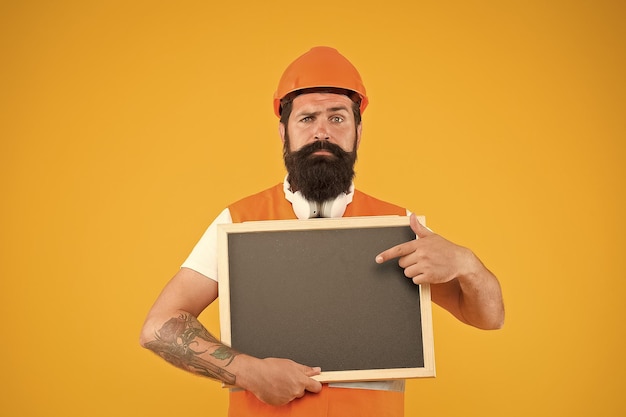 Engineer occupation Repairman engineer hold blackboard copy space Man bearded repairman builder work clothes Responsibility and garanties Installation of electrical equipment Handsome repairman