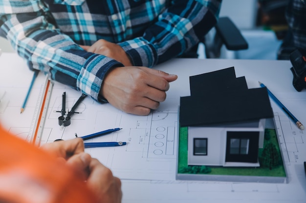 engineer people meeting working and pointing at a drawings in office for discussing Engineering tools and construction concept