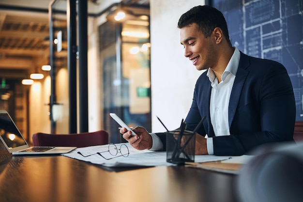 Engineer reading a text message in his office