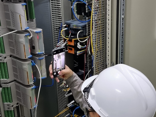 The Engineer takes a photo Interface module of the DCS control system panel