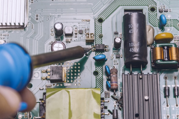 Engineer use soldering iron to repair television board