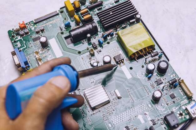 Engineer use soldering iron to repair television board