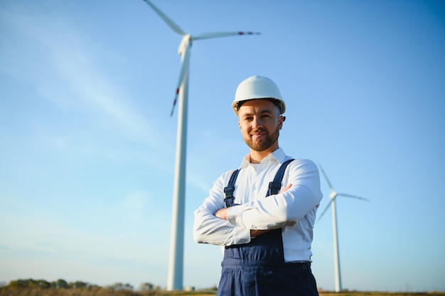 Engineer in wheat field checking on turbine production