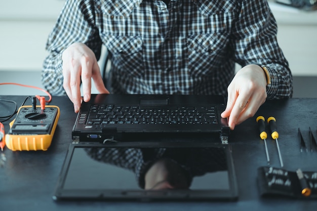 Photo engineer working on disassembled laptop