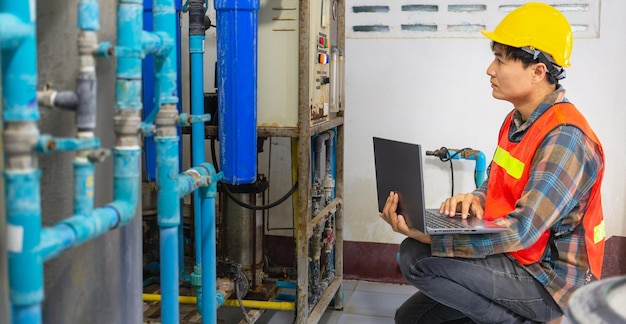 Engineer working in drinking water factory using a tablet computer to check water management system