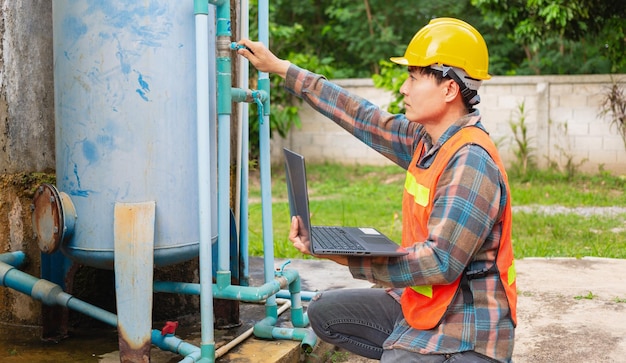 Engineer working  using a laptop computer to check water management system and boiler water pipe